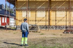 rakentaja talon edessä