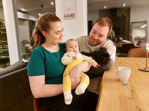 vanhemmat ja pieni lapsi kotona keittiönpöydän ääressä